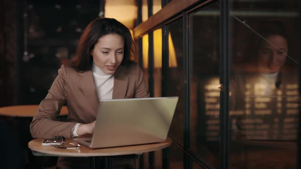 Business Woman Getting Good News on Laptop at Cafe