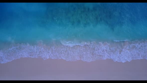 Aerial top view scenery of tranquil coastline beach trip by blue lagoon and white sandy background o