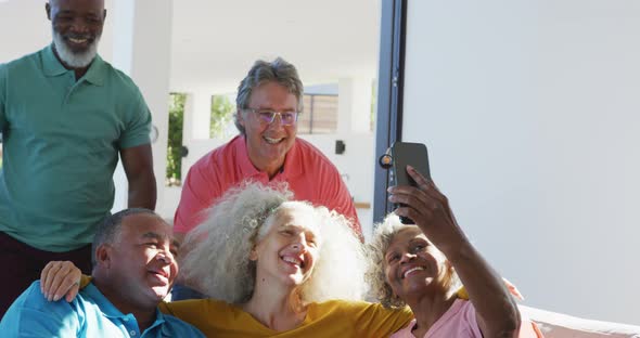 Happy senior diverse people taking selfie at retirement home