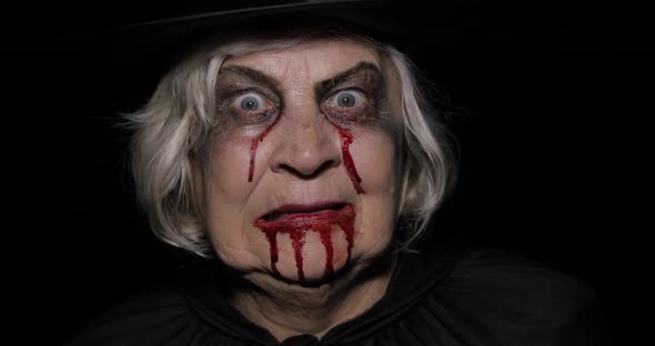 Old Witch Halloween Makeup. Elderly Woman Portrait with Blood on Her Face