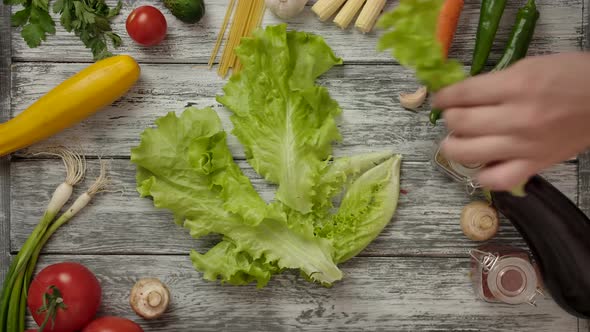 Crop People Taking Lettuce Piece By Piece From Table