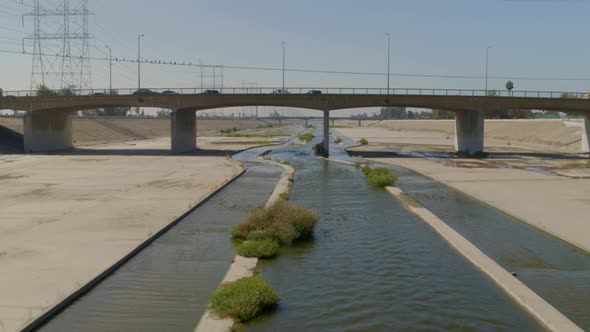 Vehicles riding on bridge and Los Angeles canal in city, United States