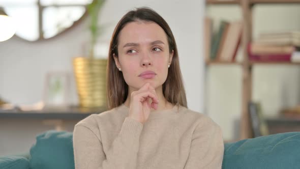 Portrait of Pensive Young Woman Thinking at Home 