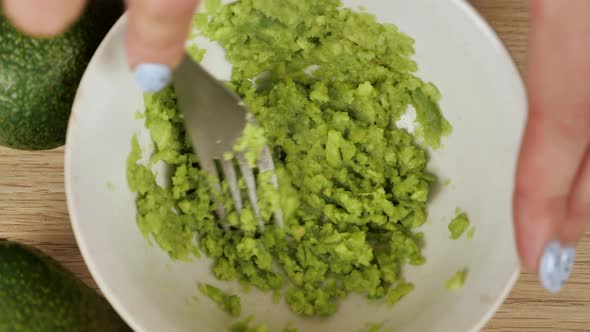 Male Chef Mashing Avocado in Bowl