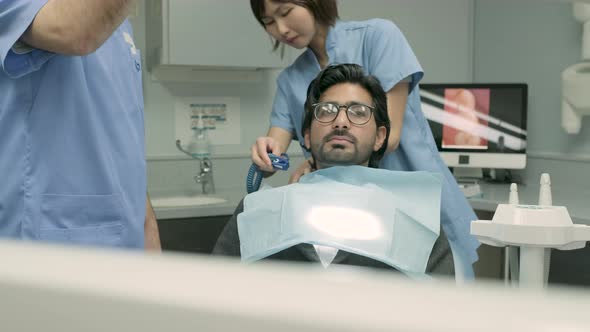 Dentist and dental assistant preparing dental treatment for patient