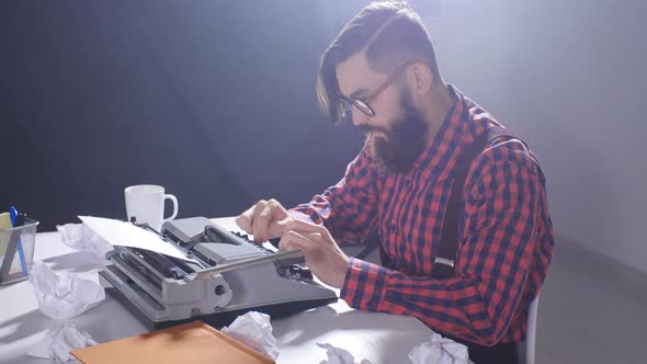 Retro Writer Concept. Young Bearded Stylish Man Writing on Old Typewriter