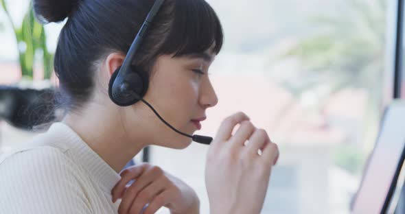 Young woman with headset working on computer