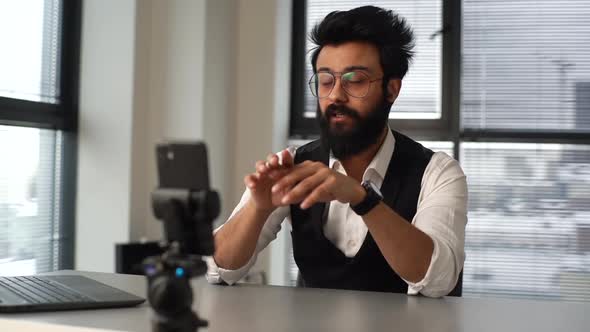 Bearded Indian Blogger Talking to Camera Record New Educational Video Vlog on Smartphone Sitting at