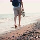 A Young Woman Walking Barefoot on the Beach During Sunset - VideoHive Item for Sale