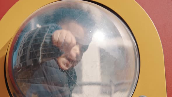 Little Boy Sitting in the Plastic House in the Park and Touching a Glass Medium Closeup Pink and