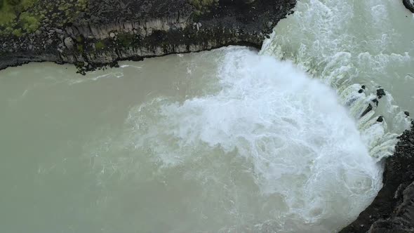 Majestic view of rapid river flowing through grassy hilly terrain