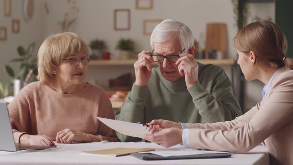 Female Financial Advisor Consulting Senior Couple at Home