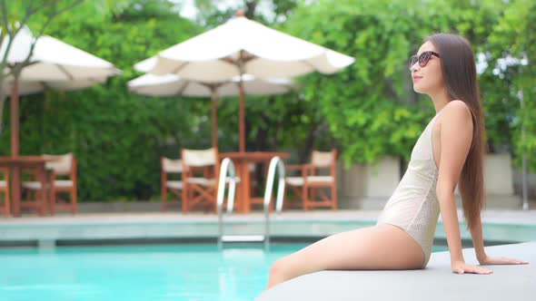 Young asian woman enjoy around outdoor swimming pool for leisure