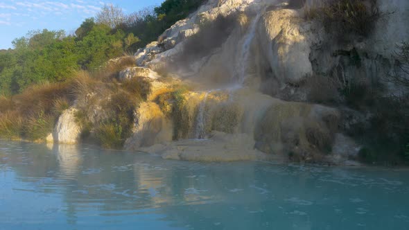 Geothermal pool and hot spring in Tuscany, Italy. Bagno Vignoni natural thermal waterfall in the mor