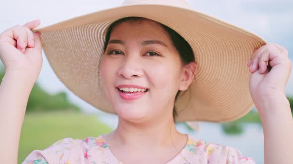 Portrait of beautiful Asian woman adjusting her hat in travel day. Slow motion