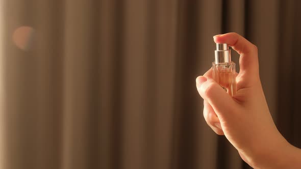 Hand spraying dust perfume, Slow motion. Applies perfume.
