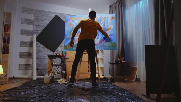 Guy Painting on Canvas with Roller