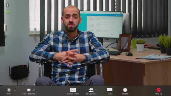 Disabled Businessman in Wheelchair Waving at Videocall