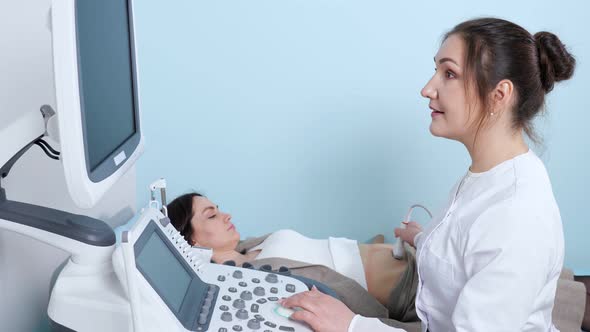 Smiling Doctor Does Ultrasonography to Woman in Hospital
