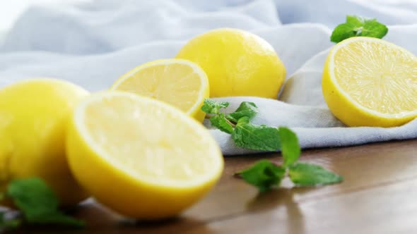 Full and half lemons with mint leaf on table