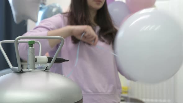 Woman Using Helium Tank Blowing Up Balloons to Decorate Home for Party Colorful Balloons for