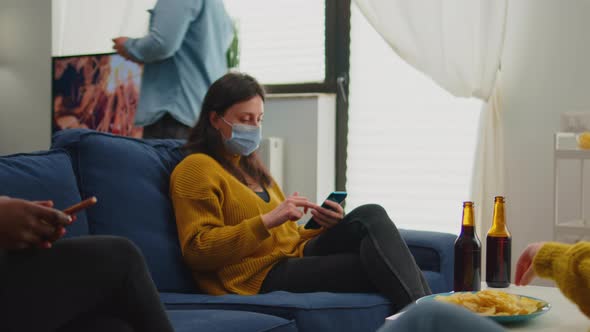 Multiethnic Friends Relaxing on Sofa Searching on Phones