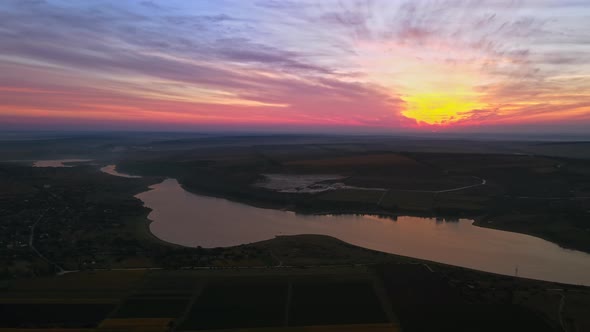 Aerial drone view of the Duruitoarea natural reservation at sunset in Moldova. River and village, hi