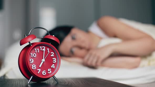 The Woman Wakes Up Switches Off the Alarm Clock and Continues to Sleep