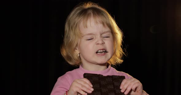 Attractive Child Eating a Huge Block of Chocolate. Cute Blonde Girl