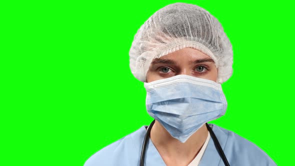 Front view of female doctor looking at camera with green screen