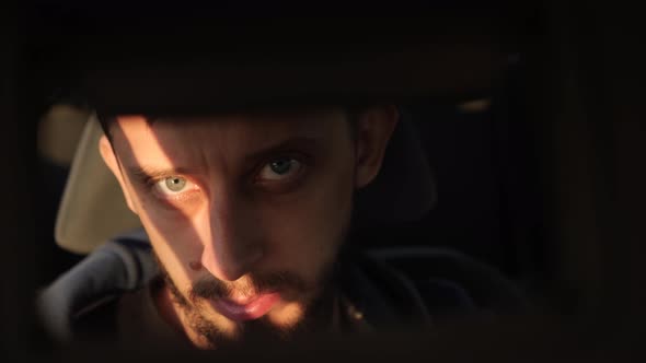 Man Looks at Himself in a Mirror While Sitting in a Car