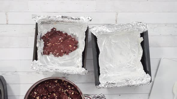 Flat lay. Step by step. Scooping melted chocolate into baking pans lined with cooking foil to make m