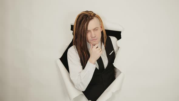 Young Man with Dreadlocks Scratching Chin