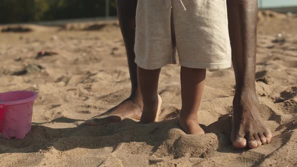 Feet of Little Boy Walking on Sand