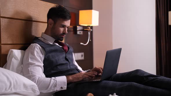 Businessman Working on Laptop in Hotel Room