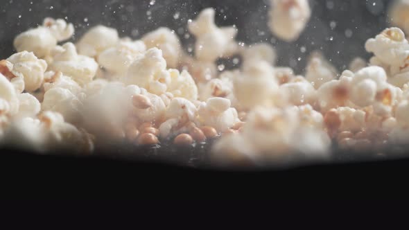 Popcorn popping on heated fry pan. Slow Motion.