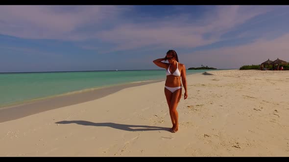 Lady alone relaxing on paradise coastline beach vacation by blue ocean with white sand background of