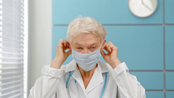 Grey haired senior woman doctor wearing surgical mask