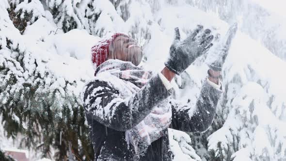 African American Man in a Snowy Winter Woodland with Snowflakes Falling From Spruce and Fir Forest