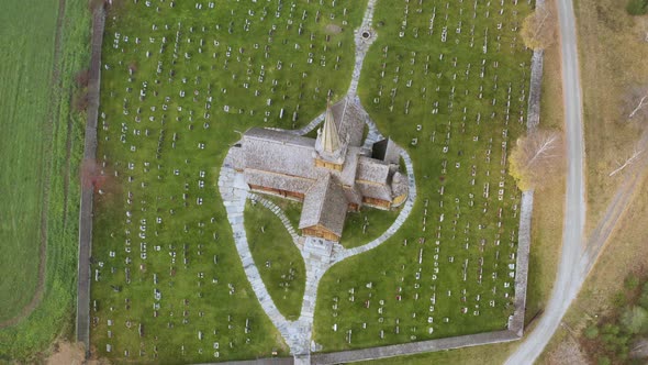 Bird's Eye View Of Lom Stave Church In Autumn Blizzard Snowstorm In Norway - aerial drone shot