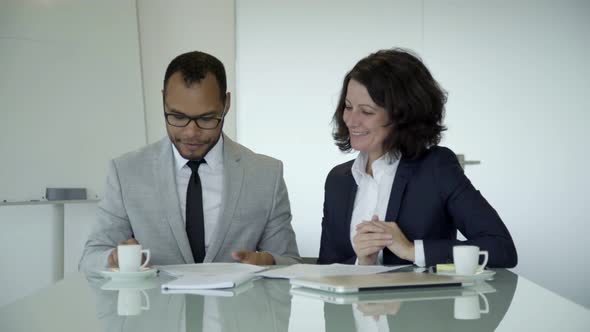 Cheerful Bearded Worker Signing Contract in Office