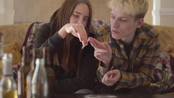 Portrait of Bad Looking Drug Addicted Man and Woman Smoking One Cigarette