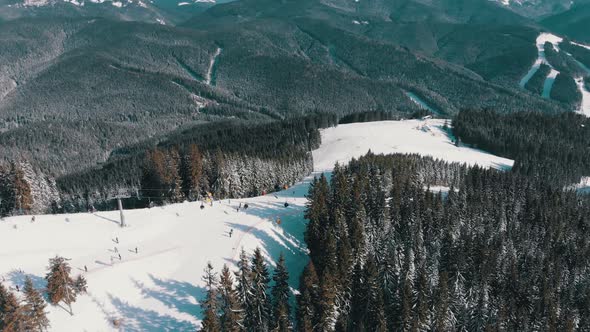 Aerial Ski Slopes with Skiers and Ski Lifts on Ski Resort, Snowy Mountain Forest