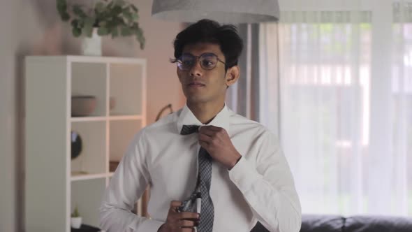Medium closeup of young Indian intern getting dressed for first day of work