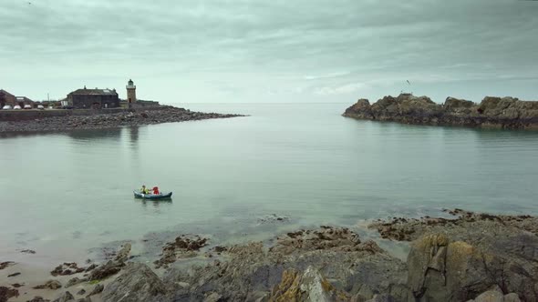 A lone canoe sailing on the sea at Portpatrick Scotland with moody sky's and calm sea