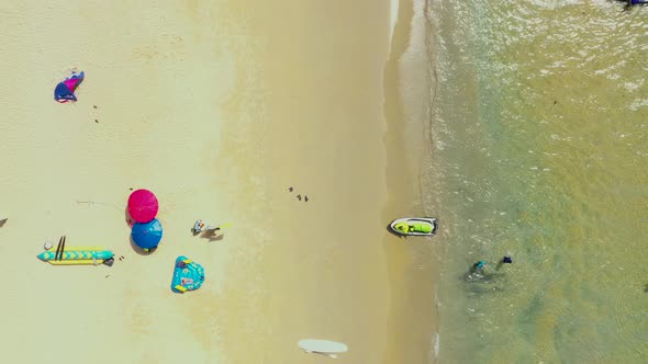 Aerial: Fly out from the beautiful beach. PHUKET, THAILAND Patong beach. sandy beach and blue transp