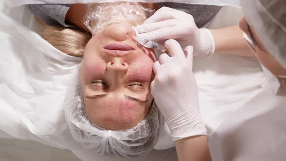 Doctor Beautician Pricks the Patient's Face