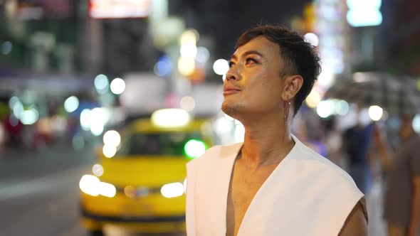 4K Confidence Asian lgbtq guy wearing woman clothes walking down city street at night