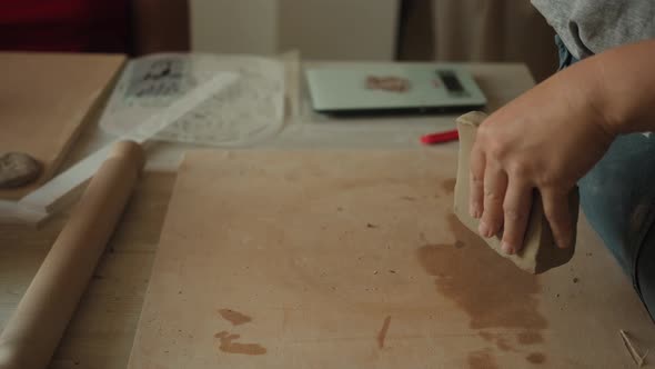 Front View of Female Potter Kneading Softly Clay on Worktop with Her Hands