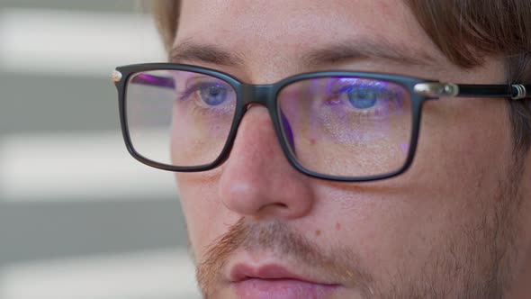 Male Eyes in Eyeglasses in Front of Laptop